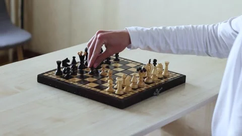A hand moves a black chess piece during a game Stock Footage 278900481