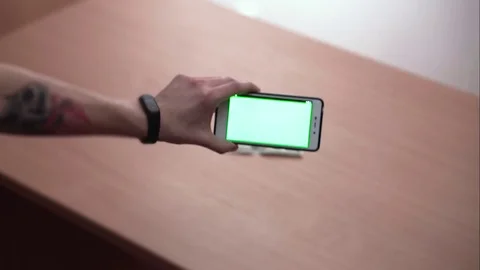 Hand moves the smartphone in different directions making dollar scan on green Stock Footage 84184860