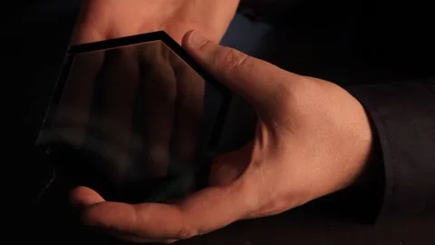 A hand moving behind a transparent OLED light panel, highlighting sleek Stock Footage 298344784