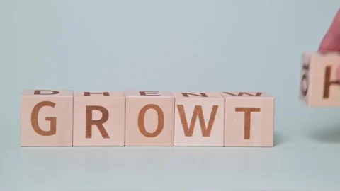 A hand moving blocks to form the words grow and growth. The action takes place Stock Footage 338187742