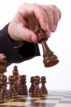 Hand moving king forward Stock Photos