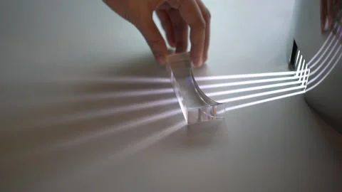 Hand moving transparent prism showing light distortion to create spectrum Stock Footage 162895815
