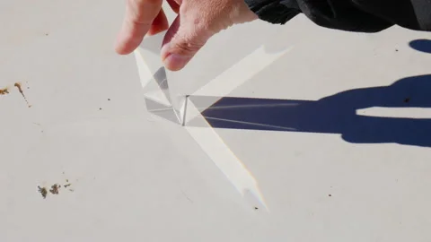 Hand moving a triangular prism in full sunlight Stock Footage 233424315