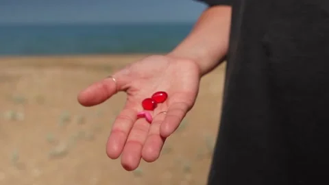 Hand with multi-colored pills. opens palm and shows pills. Vídeos de archivo 312996319