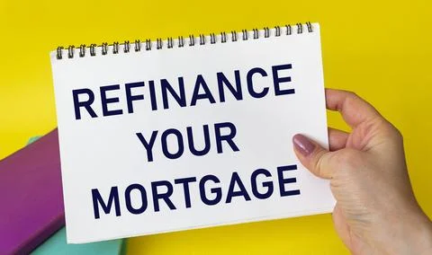 Hand with notepad and text Refinance your mortgage on yellow background Foto stock