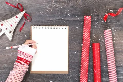 Hand with notepad Christmas tree and red gift wrapping paper Foto stock