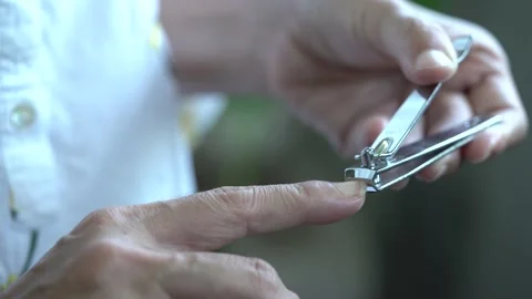 The hand of an old woman cutting her nails Stock Footage 132334026
