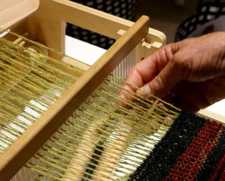 Hand of the old woman during the processing of the fabric in the ancient weav Stock-Fotos