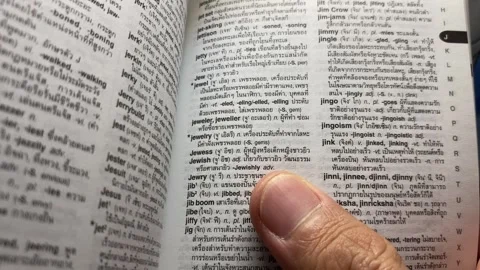 Hand open dictionary for reading. Close-up macro shot hand point "jewish" Stock Footage 248664023