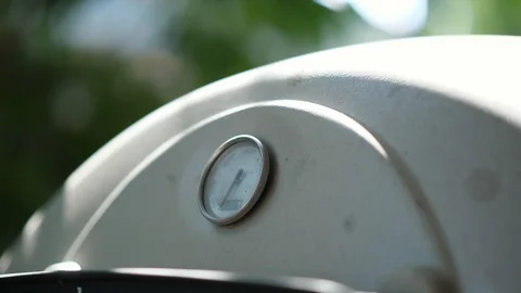 Hand open Grill lid with thermometer twice to check on food in outdoor summer Video stock 95031824