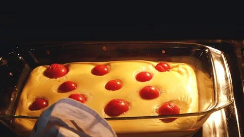 Hand open stove and take omelet with tomatoes cherry in baking dish. Homemade Stock Footage 119957341