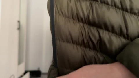 Hand opening and closing the zipper pocket on a padded winter jacket. Close up 스톡 동영상 336976623