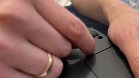Hand opening battery latch cover on laptop underside, accessing аккумулятор Stock Footage 337121464