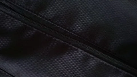 A hand is opening black bag zipper and put a bottle of hand sanitizer and Stock Footage 336611491