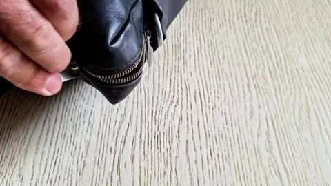Hand Opening Black Leather Bag Zipper on Wooden Floor Indoors Stock Footage 343215789
