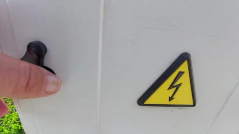 Hand opening a black plastic lock cover on an outdoor electrical cabinet with hi Vídeos de archivo 335397965