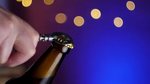  hand opening a bottle of lager beer closeup with opener Stock-Footage 129651901