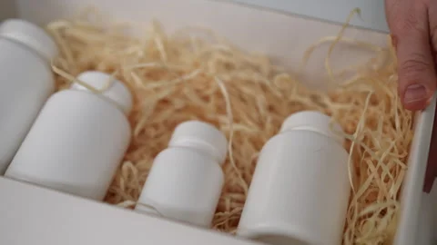Hand opening box with dietary supplements and packaging for wellness products Stock Footage 299582133