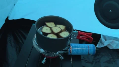Hand Opening Camping Pot Lid with Steaming Sliced Potatoes Inside Tent, Close-Up Stock Footage 323585544
