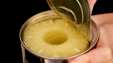 Hand Opening Can of Pineapple Slices on Black Background Stock Footage 313786743