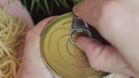 A hand opening canned meat in a tin, can for pasta close up Stock Footage 102622697