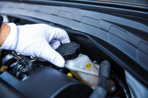 Hand opening a car engine coolant reservoir. Stock-Fotos