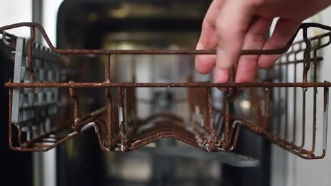 Hand opening dishwasher and pulling out a rusty basket, highlighting appliance 스톡 동영상 310563631