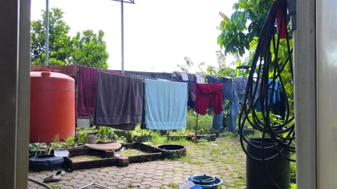 Hand Opening Door to a Sunny Backyard with Clothes Drying on a Line Vídeos de archivo 304255079