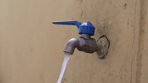 Hand is opening faucet blue handle with water flowing and closing Stock Footage 146305053