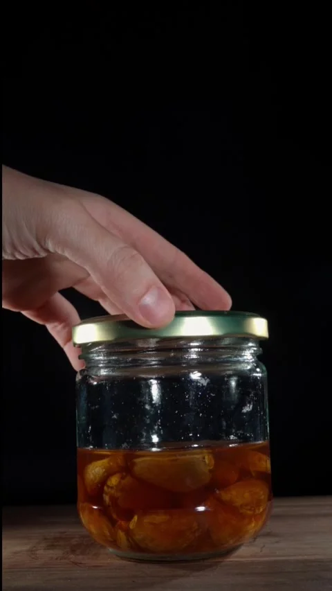 Hand Opening Fermented Garlic Honey Jar Vertical 4K Slow Motion Stock Footage 324920213