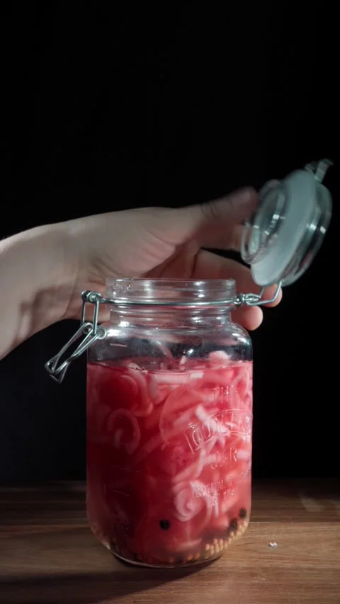 Hand Opening Jar Of Pink Pickled Onions On Wooden Table Vertical Stock Footage 324769193
