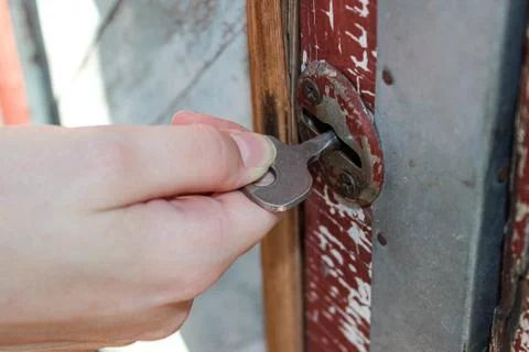 Hand opening the key lock in the old door. Foto stock