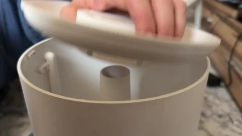 Hand opening lid of compact humidifier or diffuser container, household Stockbeeldmateriaal 337121114