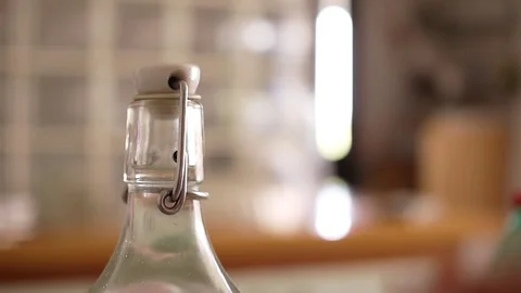 Hand Opening a Lightning Stopper Bottle of Sparkling Water Stock Footage 78923077
