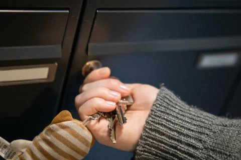 Hand opening mailbox with keys. Stock Photos