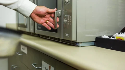 Hand opening microwave to remove left overs Stock Footage 32243140