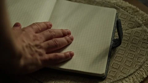 Hand opening notebook and placing blue pen on blank grid pages, close up Stock Footage 346252412