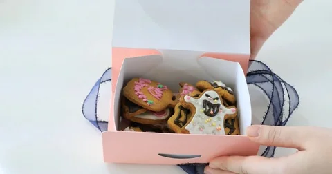 Hand opening pink gift box with ribbon  and showing halloween cookies Stock Footage 81377135
