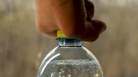 Hand opening plastic bottle with carbonated sparkling water and bubbles Stock-Footage 335540499