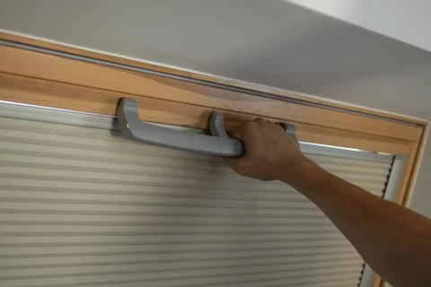 Hand opening plastic window with handle and blinds in wooden frame Photos