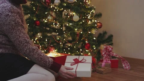 Hand opening red gift box yellow Christmas lights fir tree ornaments decoration Stock Footage 164857571
