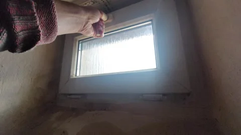Hand Opening a Small White Plastic Window for Ventilation in a Basement Stock Footage 333644286