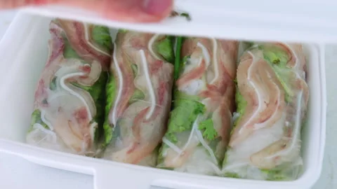 Hand opening takeaway box with pork ear spring rolls Stock Footage 337360183