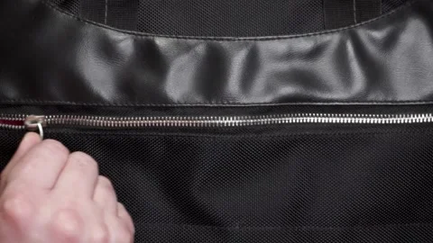 Hand opens and closes the metal zipper Stock Footage 284745138