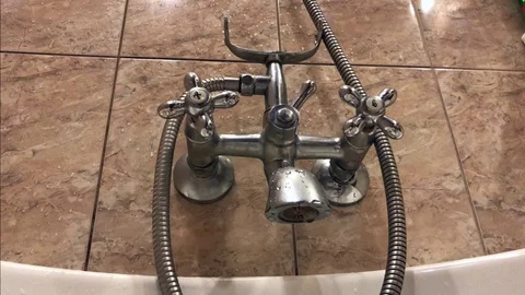 The hand opens and closes water in the metal crane in the bathroom Stock Footage 99626566