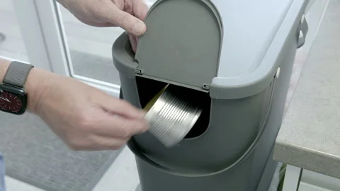 Hand opens bin with clear recycling symbols and places recycling into bin. Stock Footage 342020760