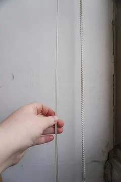 The hand opens the blinds. Stock Photos