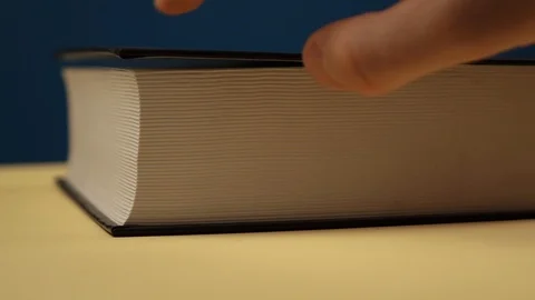 The hand opens the book and flips through the pages close up Vídeo Stock 120297122