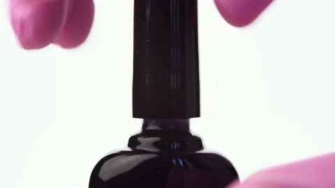 A hand opens a bottle of purple nail polish Stock Footage 196223397