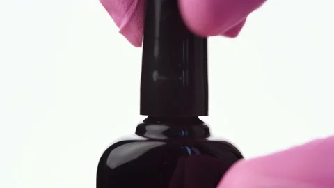 A hand opens a bottle of shiny dark green nail polish Stock Footage 196223194